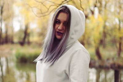 Portrait of woman standing against tree