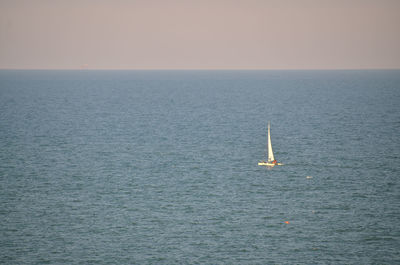 Sailboat sailing on sea against sky