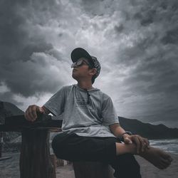 Full length of boy looking away against sky