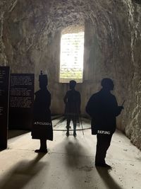 Rear view of silhouette people standing against window