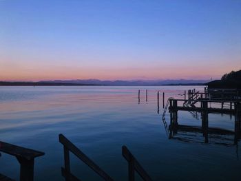 Pier on sea against sky during sunset