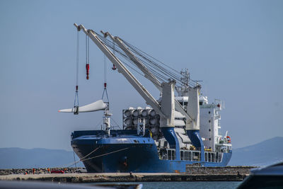 Ship moored at harbor against sky