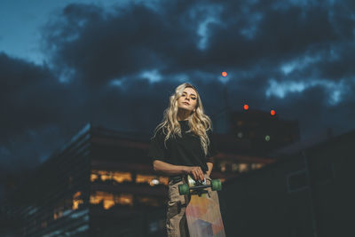 Woman standing against sky at night