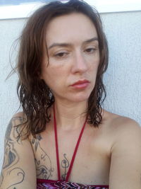 Portrait of beautiful young woman against wall