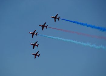 Low angle view of airshow against sky