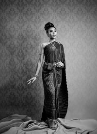 Girl wearing sari while standing against wall