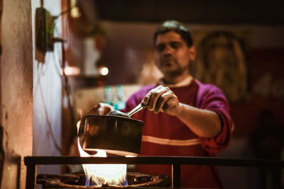 Indian man making tea in kitchen