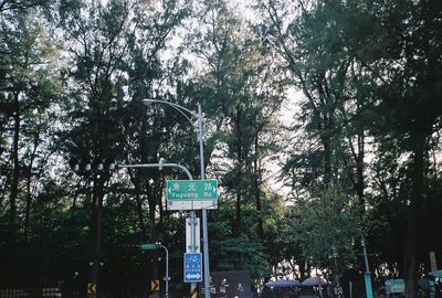 Low angle view of road sign against trees