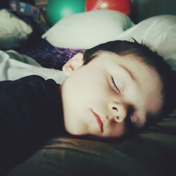 Close-up portrait of baby sleeping on bed