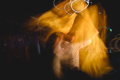 Rear view of woman standing against black background