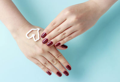 Close-up of woman hand against blue background