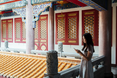 Full length of woman sitting on building