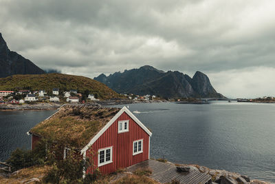 Houses by sea and mountains against sky