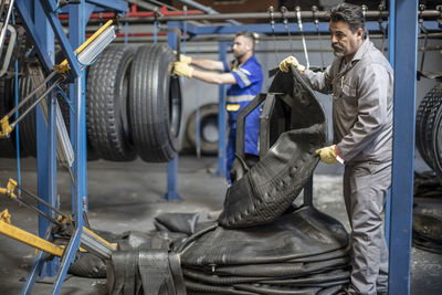 Two tire repairmen working in factory