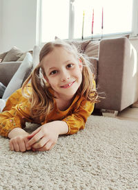 Portrait of cute girl smiling on sofa at home