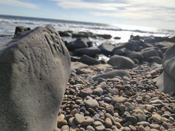 Close-up of stones on beach against sky