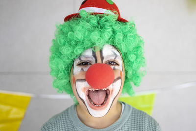 Mother painting her son's face like a clown