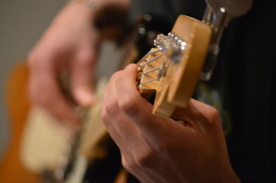 Midsection of man playing guitar