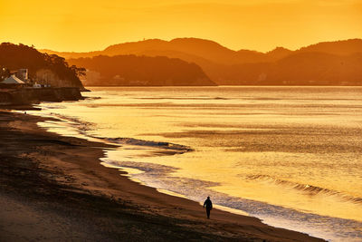 Scenic view of beach against moody sky during sunrise