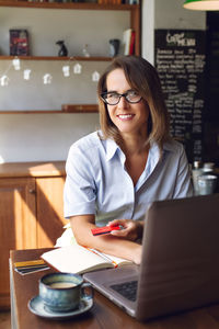 Businesswoman using laptop at office