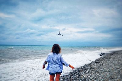 Rear view of woman standing on beach