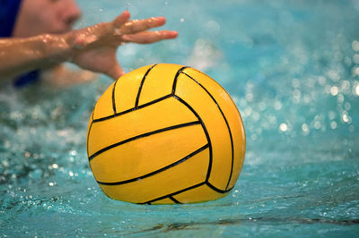 Close-up of hand on sea by swimming pool