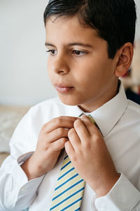 Close-up of boy wearing school uniform at home