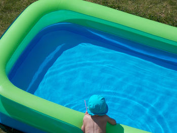 High angle view of child leaning on inflatable pool