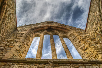 Low angle view of old building against cloudy sky