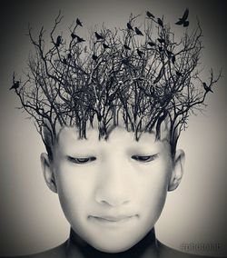 Close-up of boy against bare tree