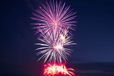 Low angle view of firework display at night