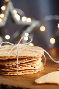 Close-up of cookies on table against illuminated christmas lights