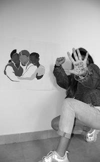 Digital composite image of woman sitting on wall