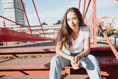 Portrait of young woman sitting on staircase