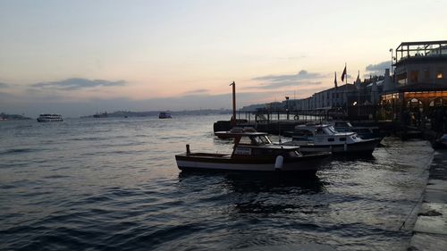 Boats in sea at sunset