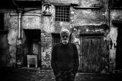 Portrait of man standing against building