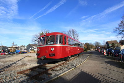 Train on railroad track in city against sky