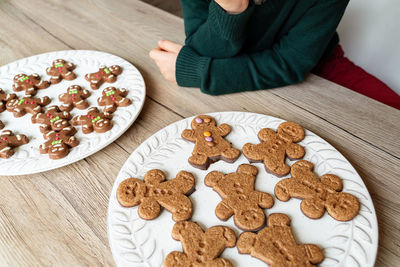 Midsection of boy holding gingerbread cookies in plate
