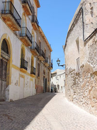 Narrow street amidst buildings against sky