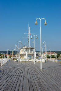 Street light on boardwalk against clear blue sky