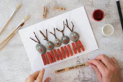 Diy merry christmas deer on greeting card postcard made of pebbles, sea stones, clothespins 