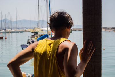 Rear view of man on boat at harbor