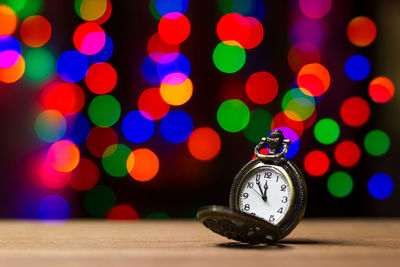 Close-up of illuminated clock on table