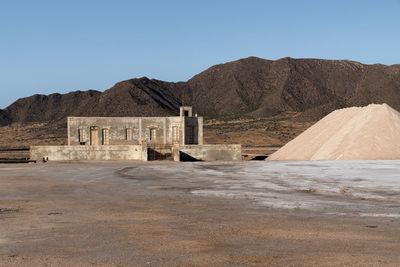 Built structure on desert against mountain range