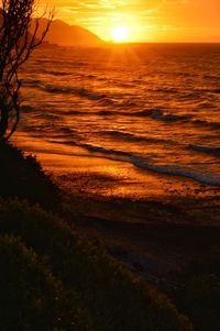 Scenic view of sea against dramatic sky during sunset