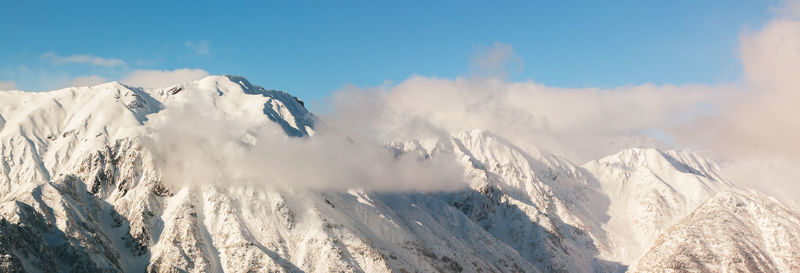 Panoramic view of snowcapped mountains against sky