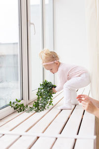 Rear view of woman using mobile phone while sitting on table