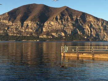 Scenic view of lake by mountains against sky