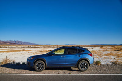 Car on road against clear blue sky