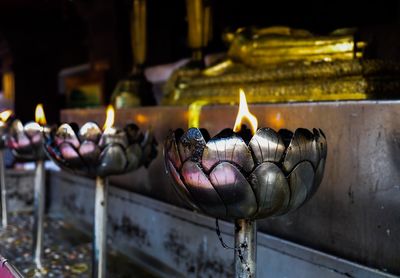 Close-up of illuminated candles in temple